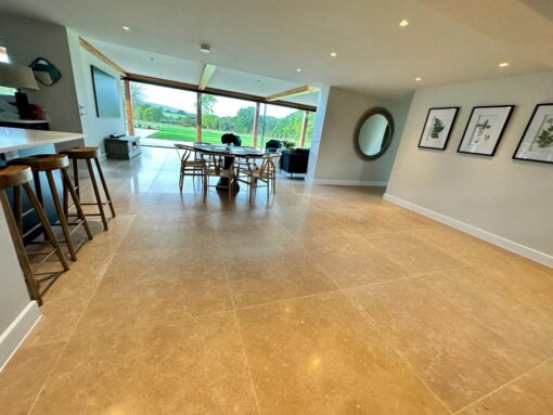 Beige stone flooring in kitchen and dining room