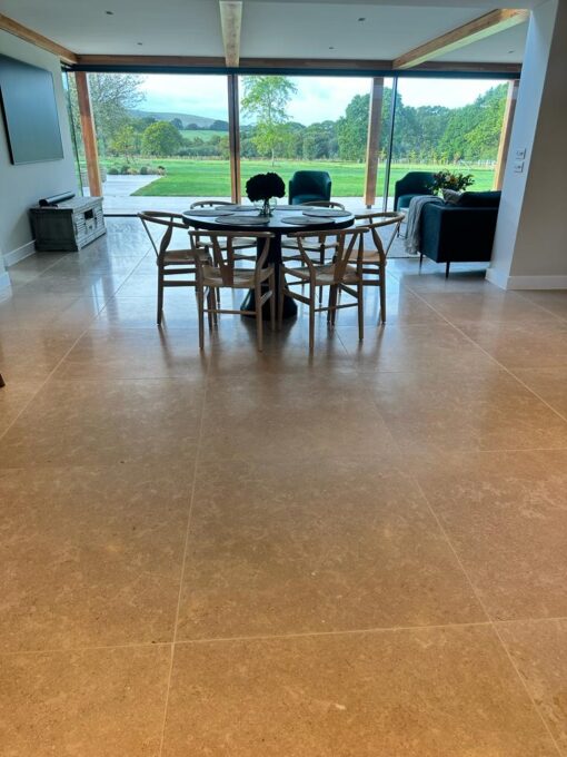 beige stone floor tiles in large dining room with view onto the garden