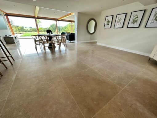 Large luxury dining room with beige stone floor